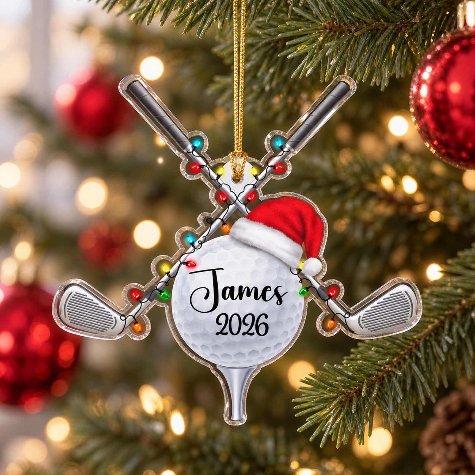Personalized golf ball and clubs acrylic ornament hanging on a bright Christmas tree branch