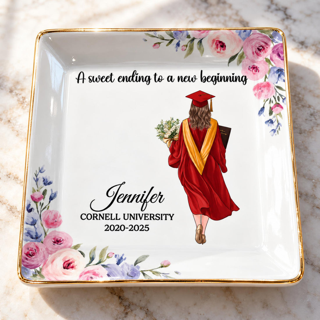Close-up of glossy ceramic glaze, gold rim, and floral print on personalized graduation jewelry dish