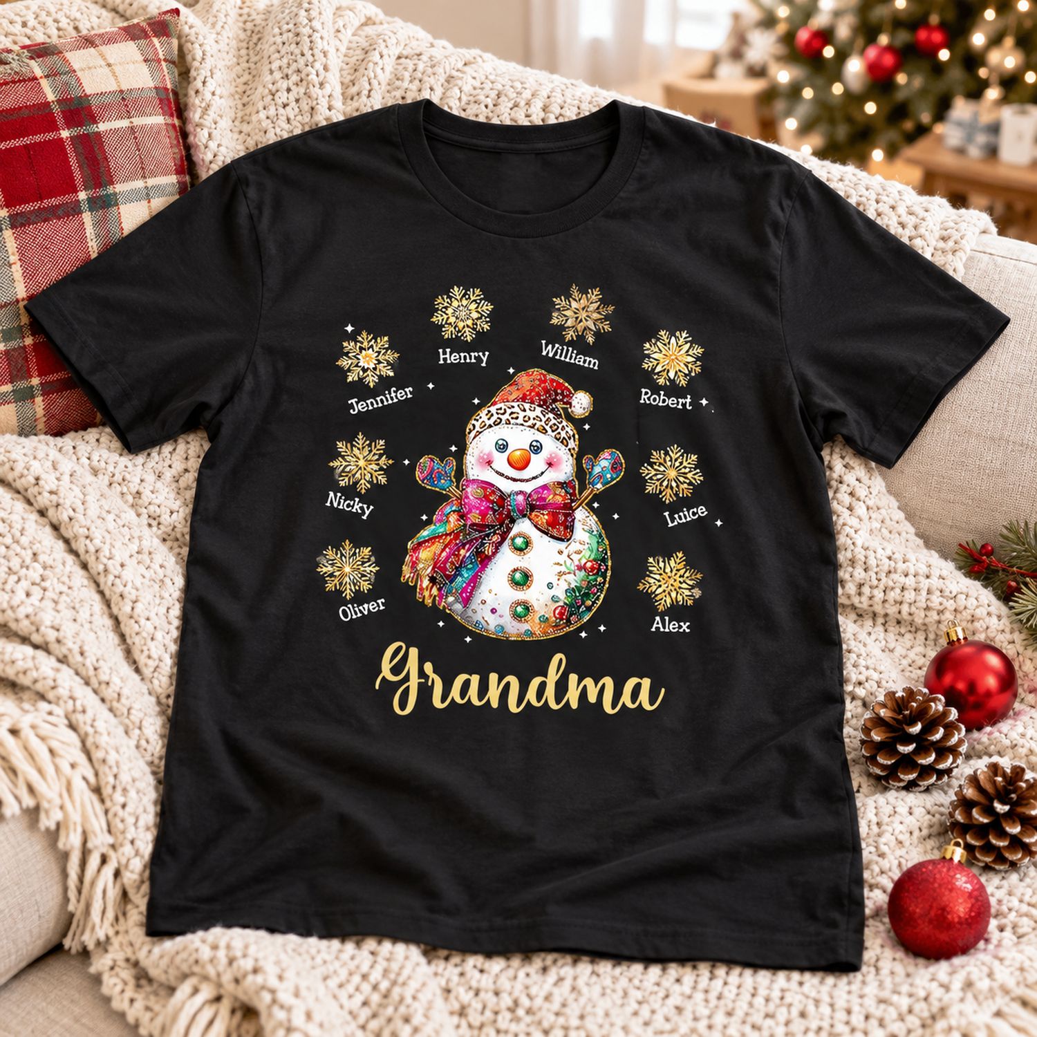 Personalized Grandma Christmas snowman black t-shirt laid on a cozy holiday sofa