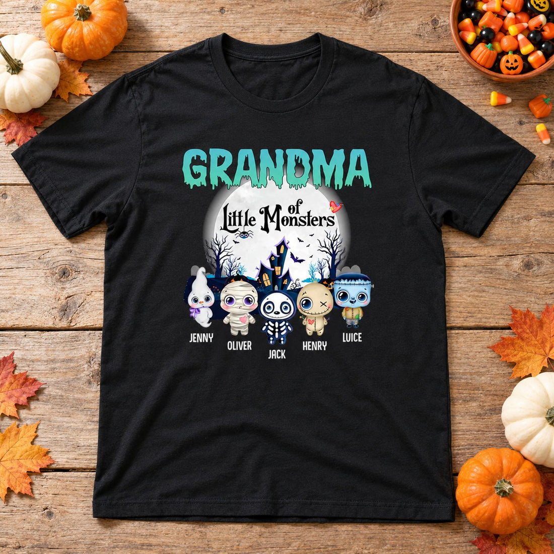 Personalized Grandma Of Little Monsters Halloween t-shirt flat lay with pumpkins and fall leaves