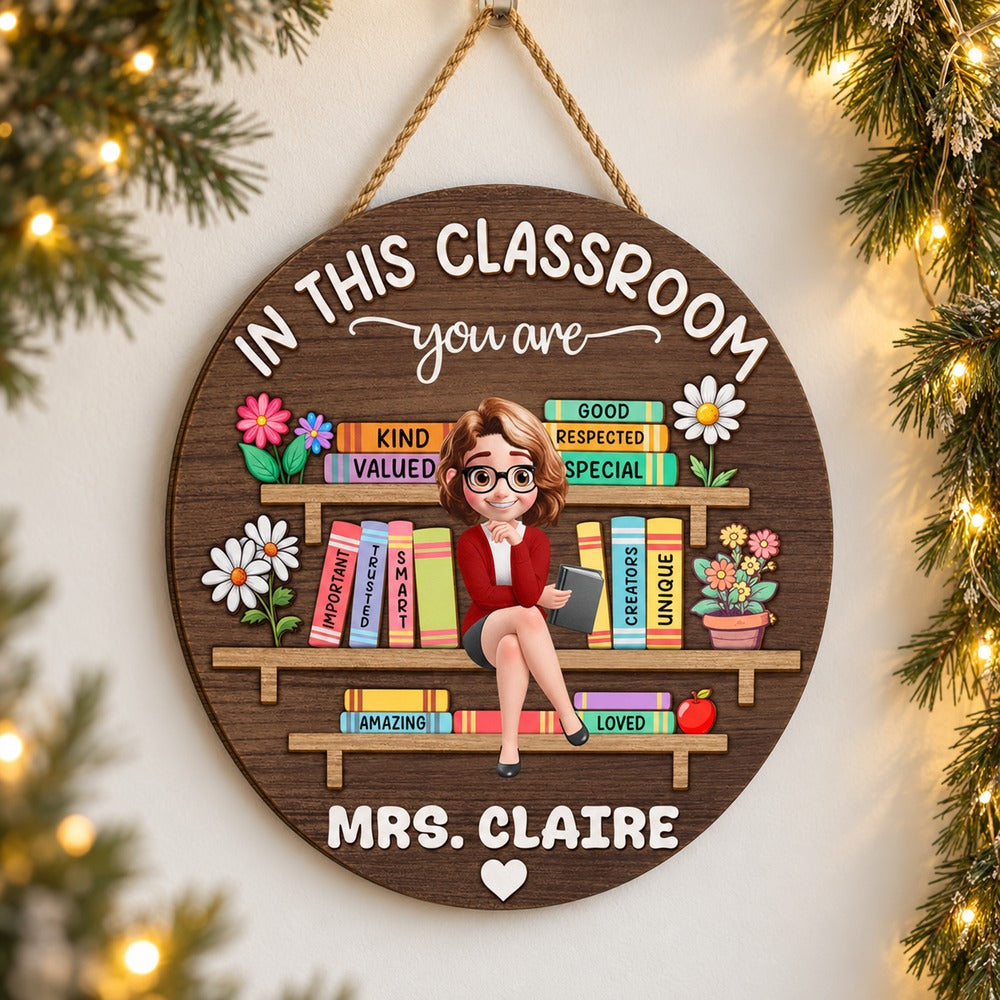 Custom teacher round wood sign Mrs. Claire hanging beside holiday pine garland and warm fairy lights