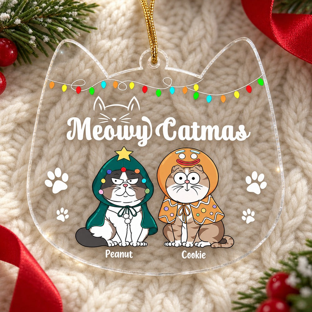 Custom cartoon cats Christmas acrylic ornament lying flat on cream knit fabric with pine greenery