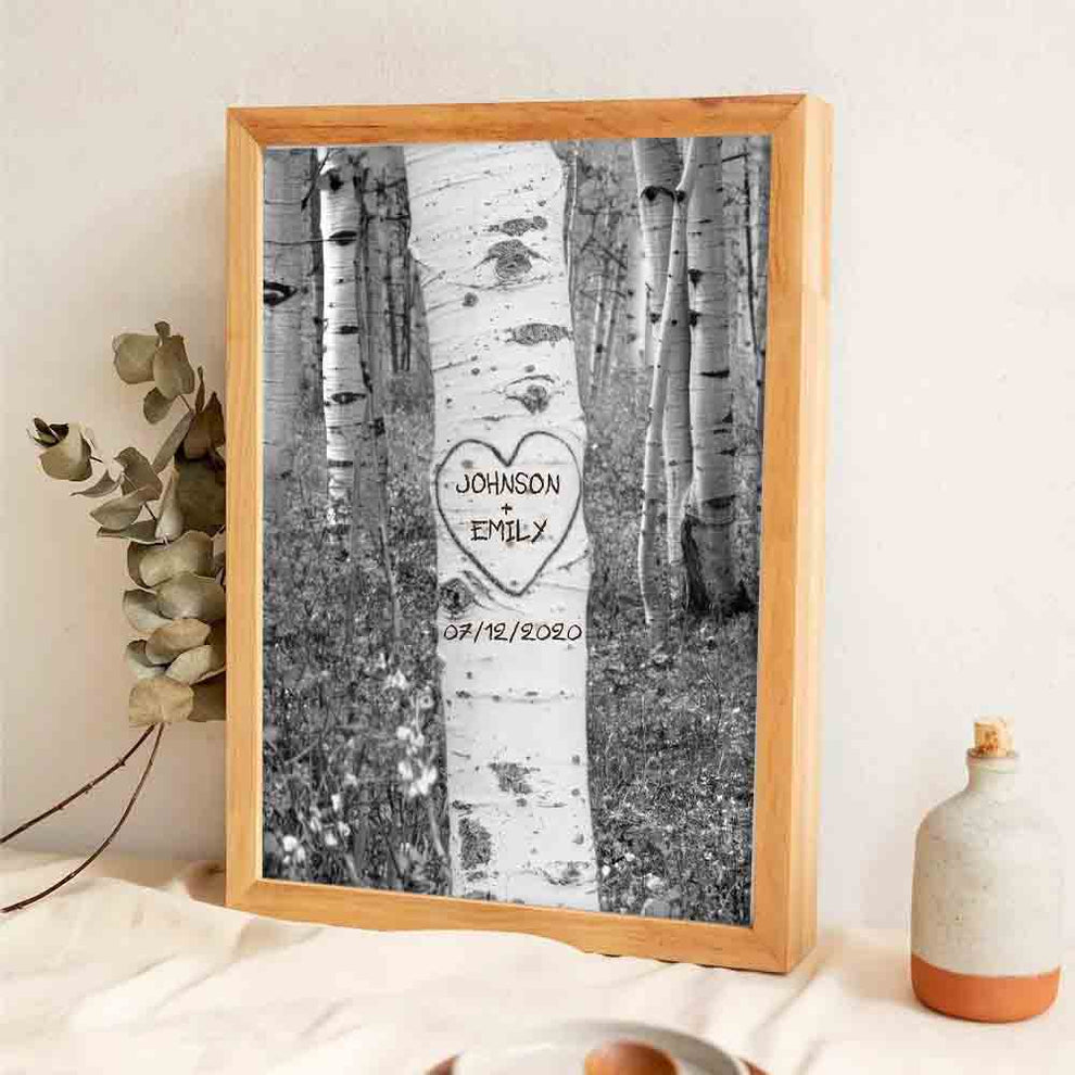 Personalized Couple Names Tree Carving poster, leaning against a wall on a wooden floor