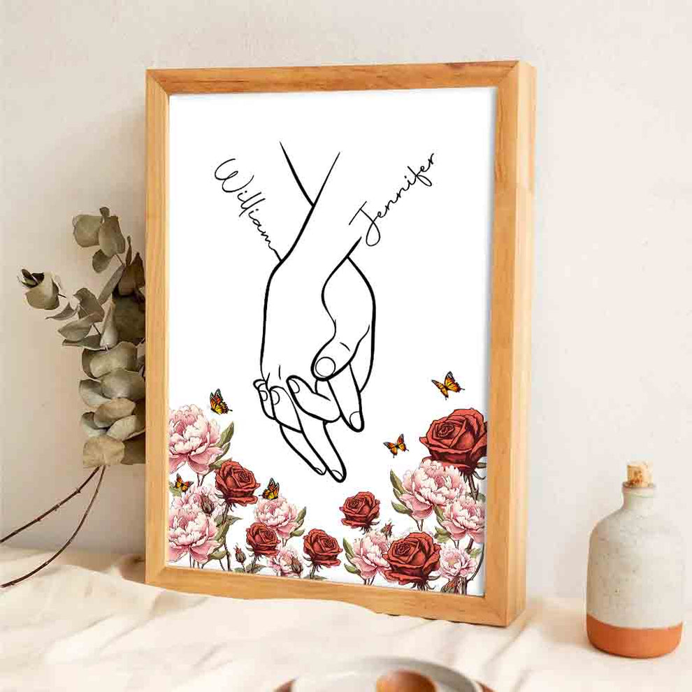 Personalized I Love You Couple Hand Print Birth Flower poster, leaning against a wall on a wooden floor