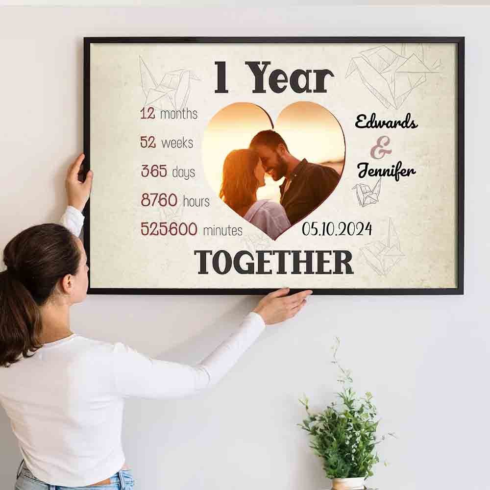 Personalized Custom Photo 1 Year Together Heart-Shaped Couple canvas print, a woman hanging the framed print on a wall