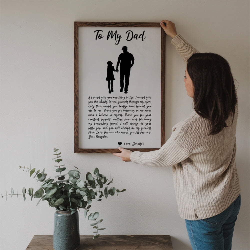 Personalized From Daughter To My Dad poster, a woman hanging the framed print on a wall