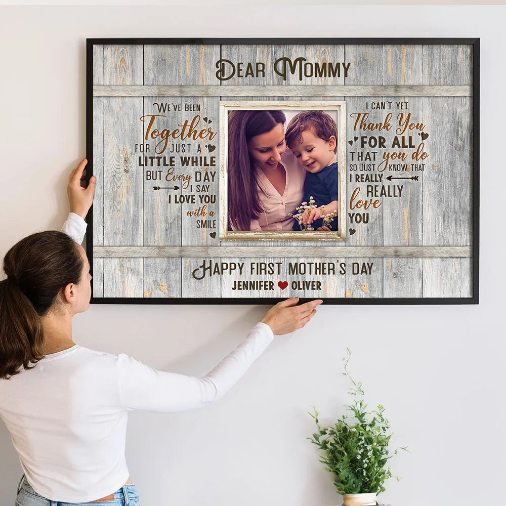 Personalized Happy First Time Mother’s Day poster, a woman hanging the framed print on a wall