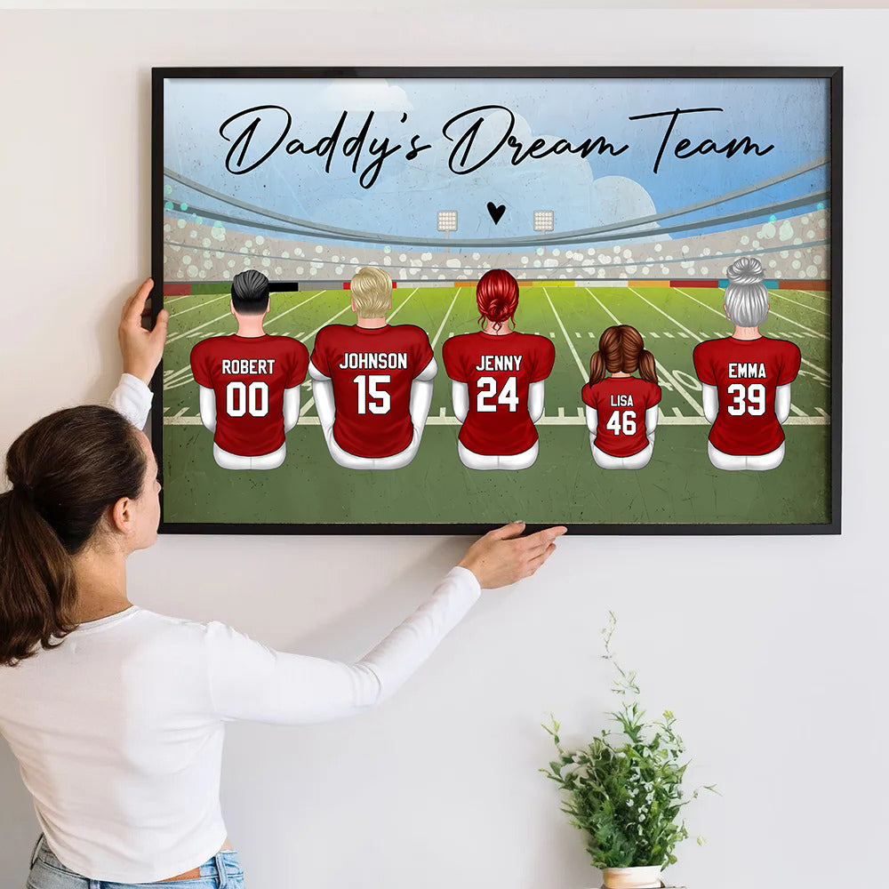 Personalized Football Dad Grandpa Dream Team poster, a woman hanging the framed print on a wall