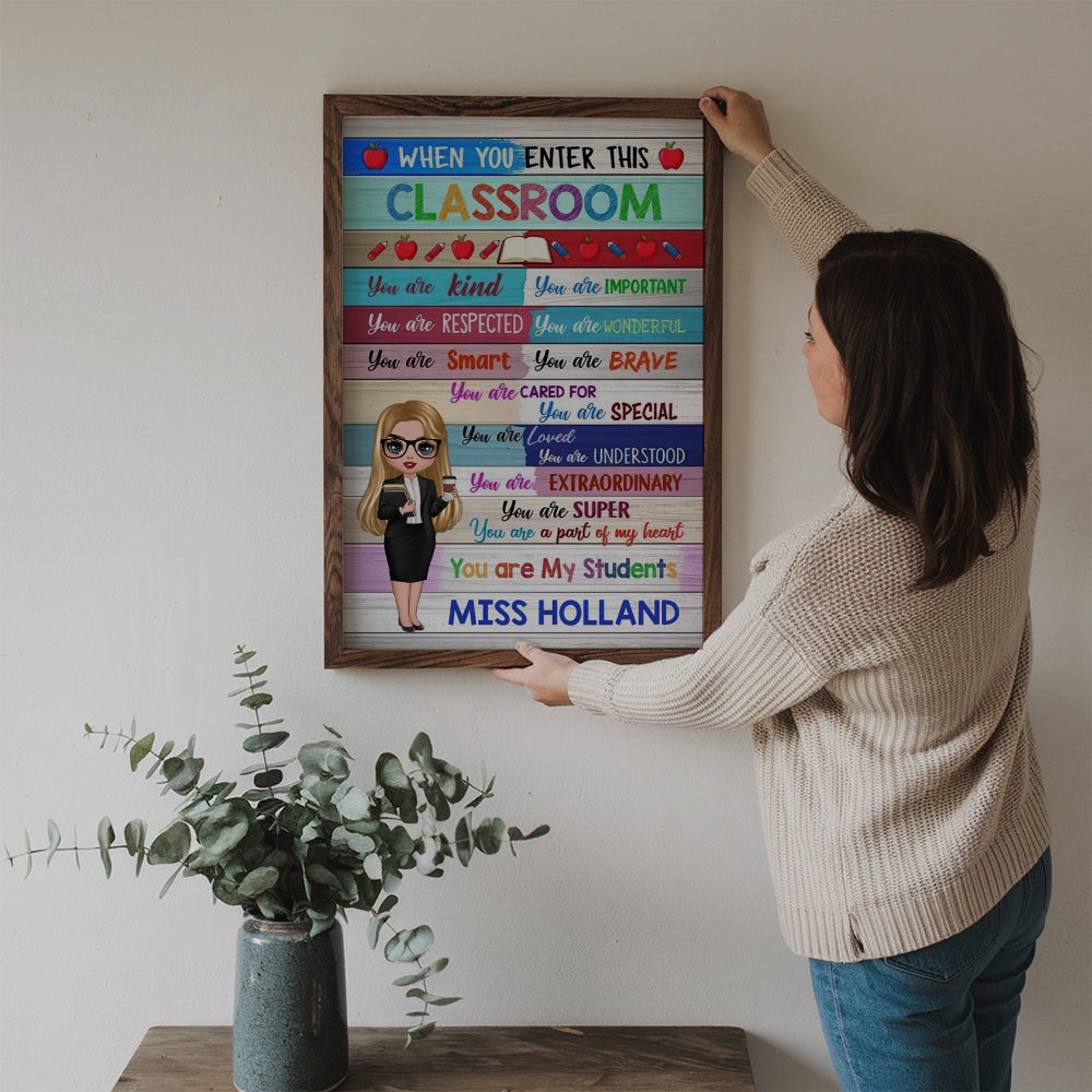 Personalized Colorful Doll Teacher Classroom Welcome poster, a woman hanging the framed print on a wall