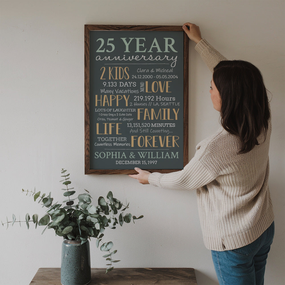 Personalized 25-Year Milestone Anniversary Couple canvas print, a woman hanging the framed print on a wall