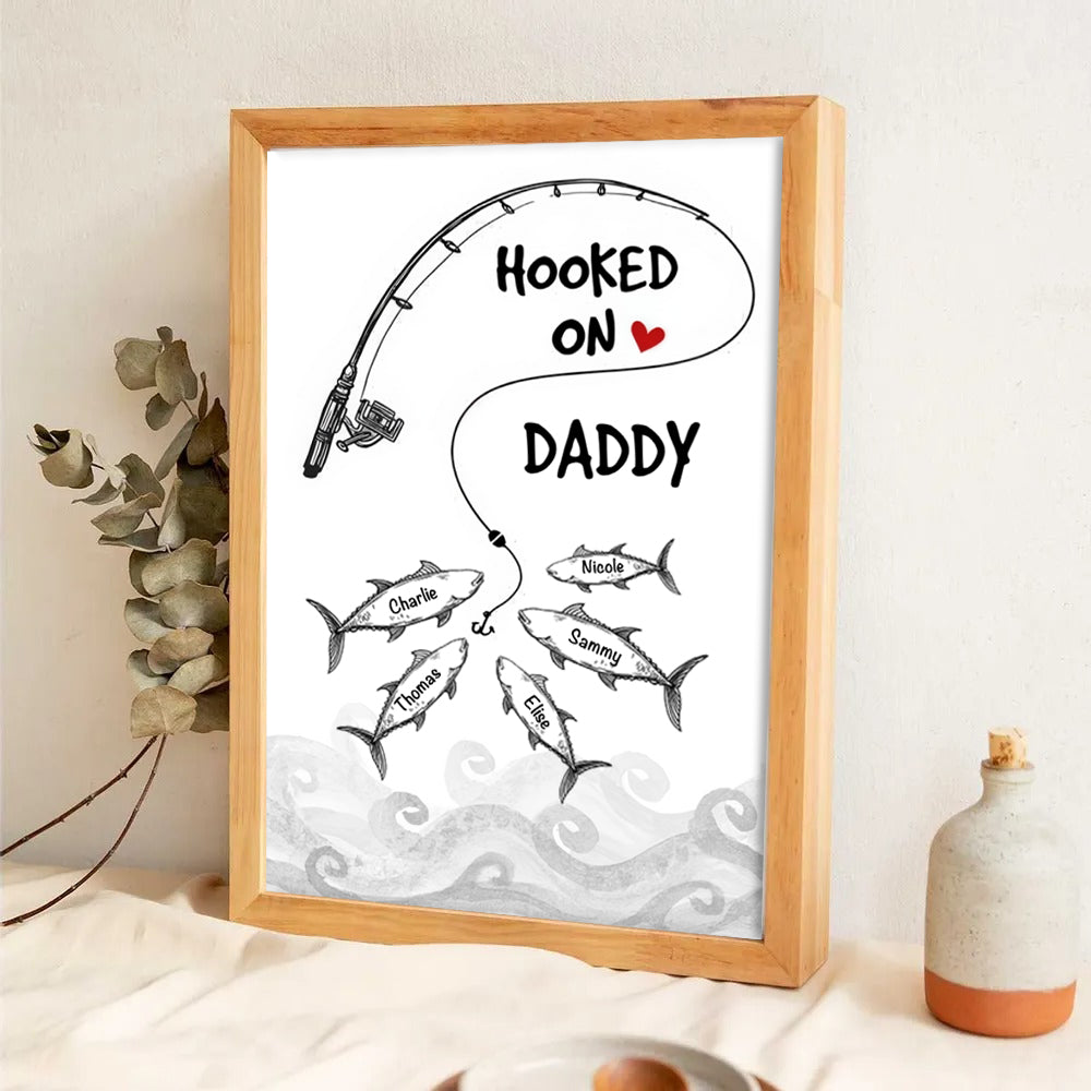 Personalized Fishes Hooked On Daddy Grandpa poster, framed in a bright living room
