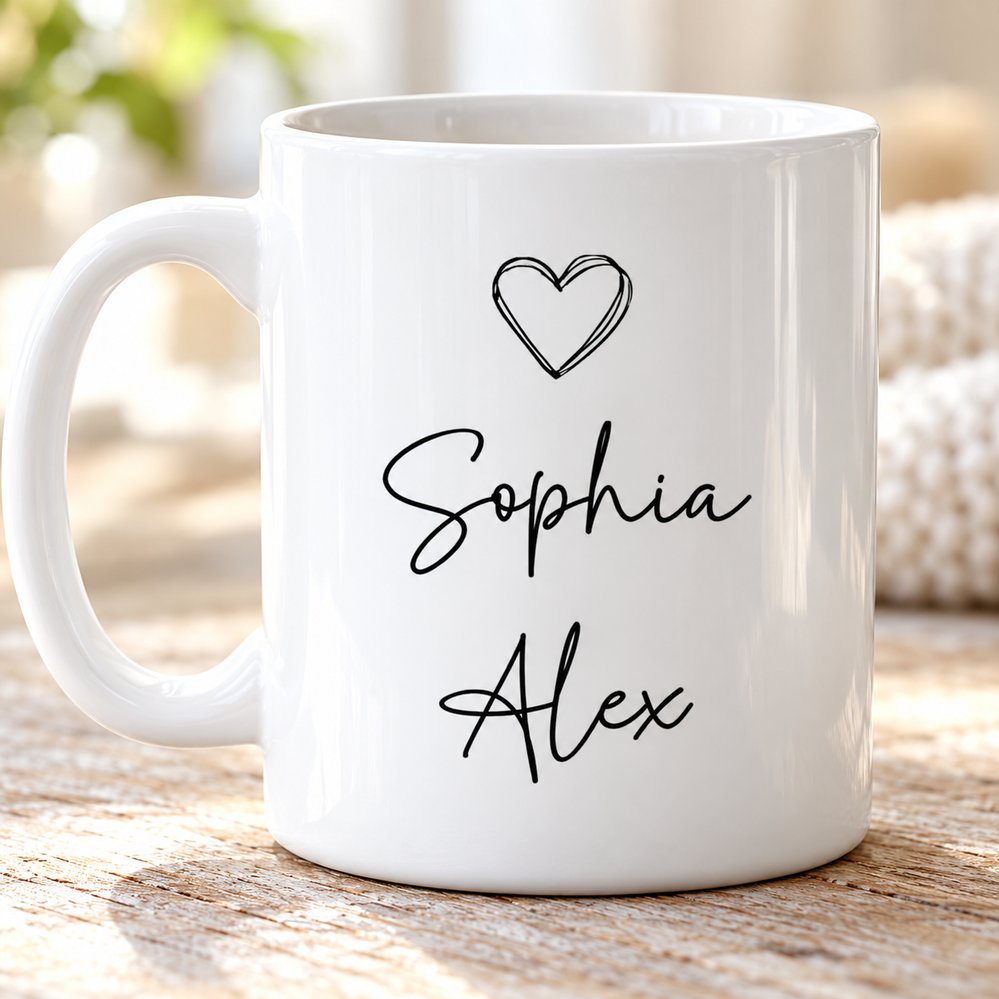 Close up detail of glossy white ceramic mug showing black heart and cursive kid names print