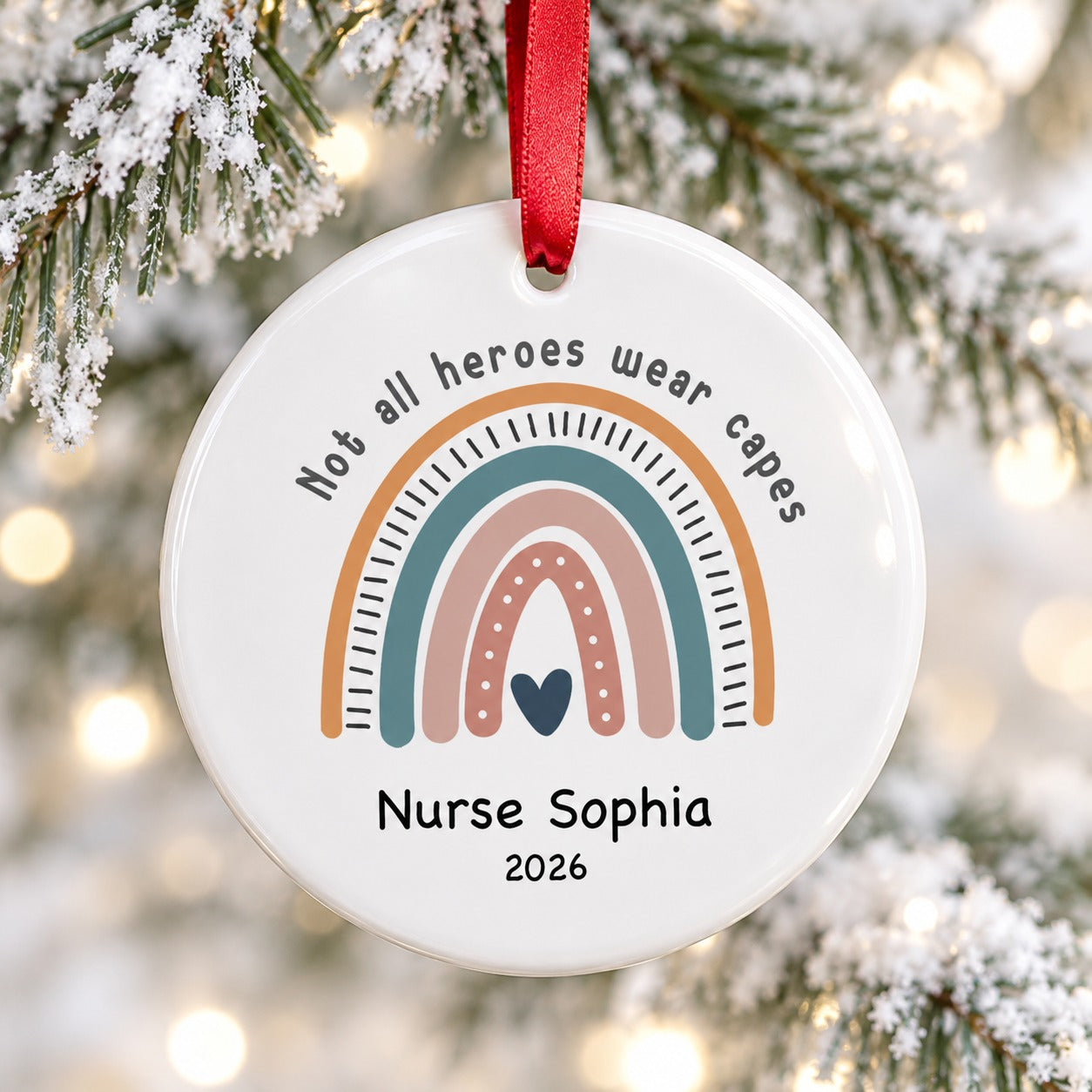 Close-up detail of glossy white ceramic nurse ornament showing rainbow print and red ribbon