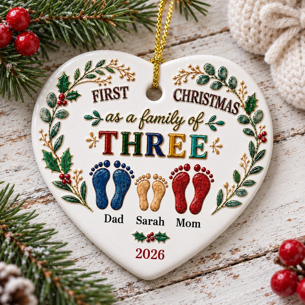 Heart ceramic ornament for baby first Christmas lying flat on festive table with pine sprigs