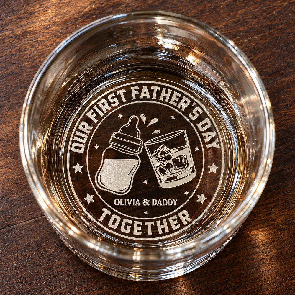 Macro closeup of laser engraved bottom of First Fathers Day whiskey glass with baby bottle and glass