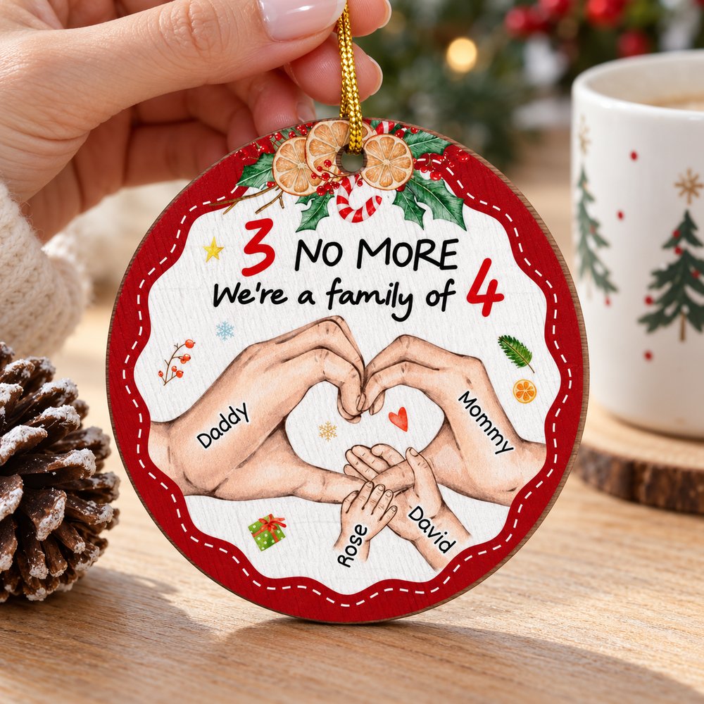 Hand holding the 4 inch family of four wood ornament to show true size