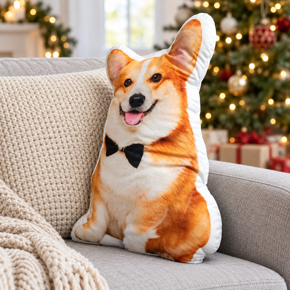 Custom corgi shaped photo pillow with black bow tie on a sofa near a Christmas tree