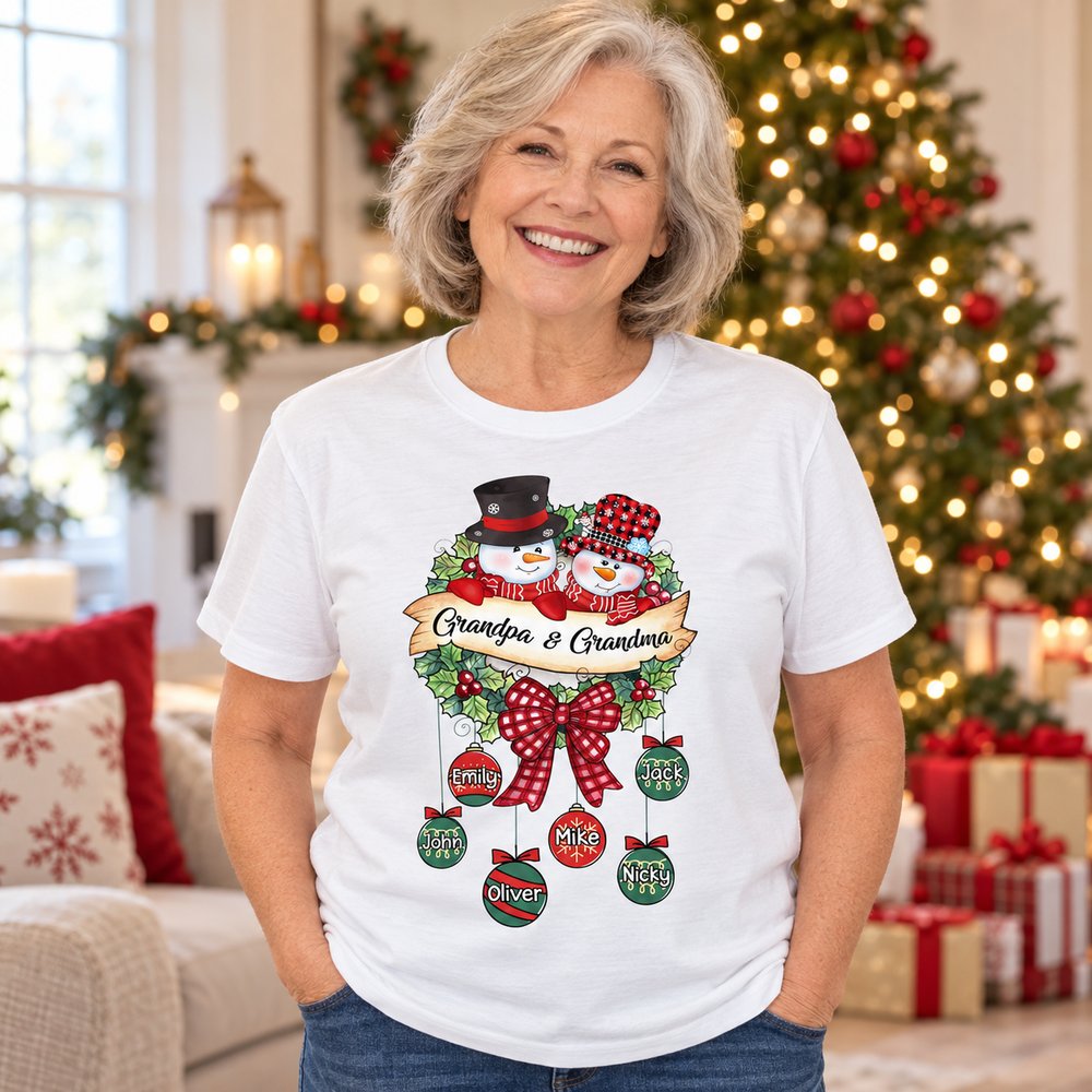 Grandma wearing personalized Snowman Grandpa and Grandma Christmas t-shirt in festive living room
