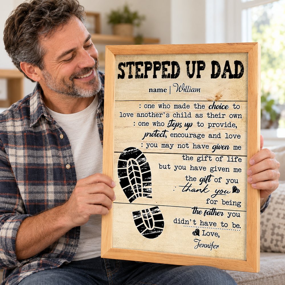 Happy stepdad holding his personalized Stepped Up Dad framed canvas gift in a bright room