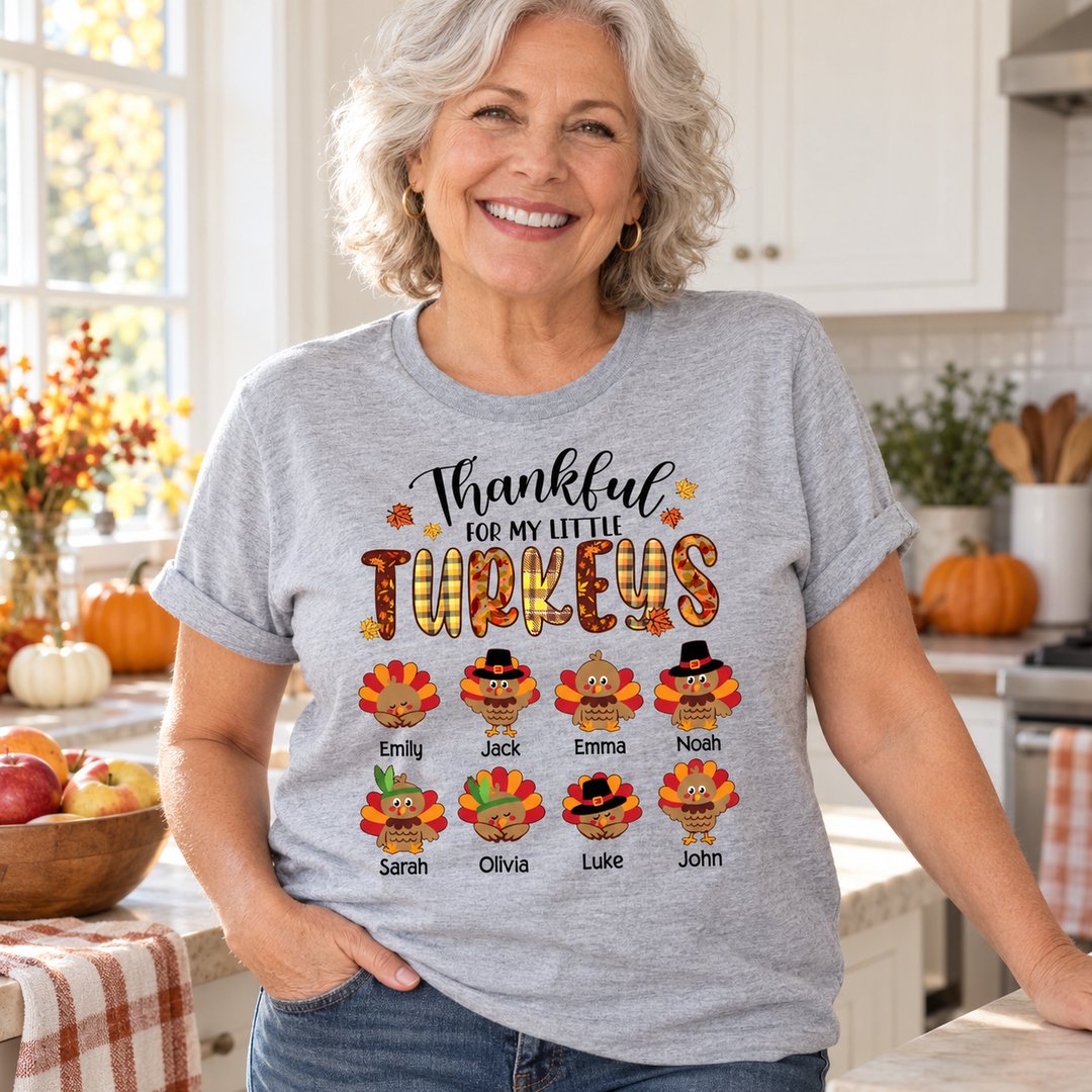 Grandma wearing Thankful For My Little Turkeys personalized t-shirt in a bright autumn kitchen