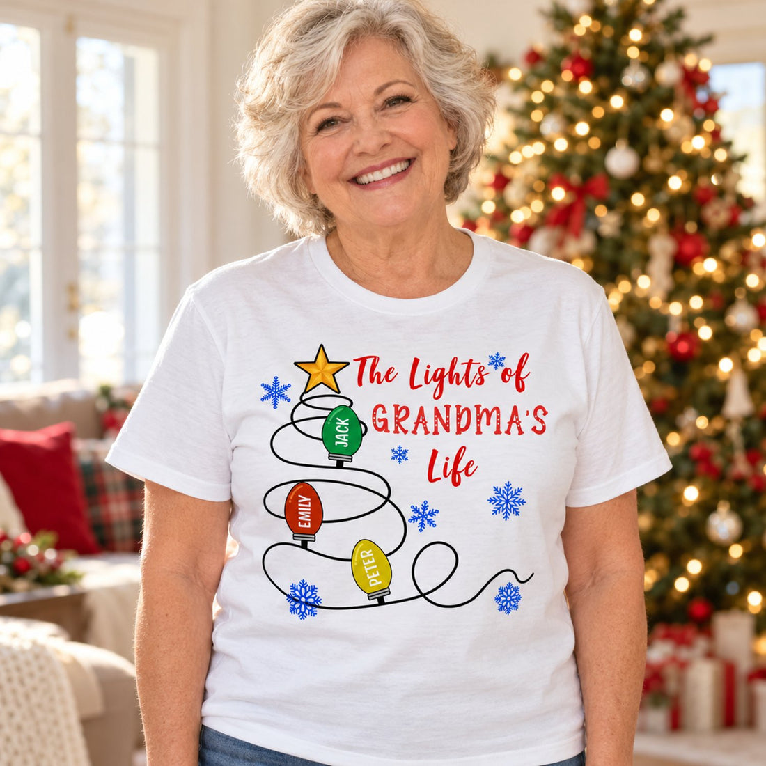 Grandma wearing The Lights of Grandmas Life personalized Christmas t-shirt in a bright holiday living room