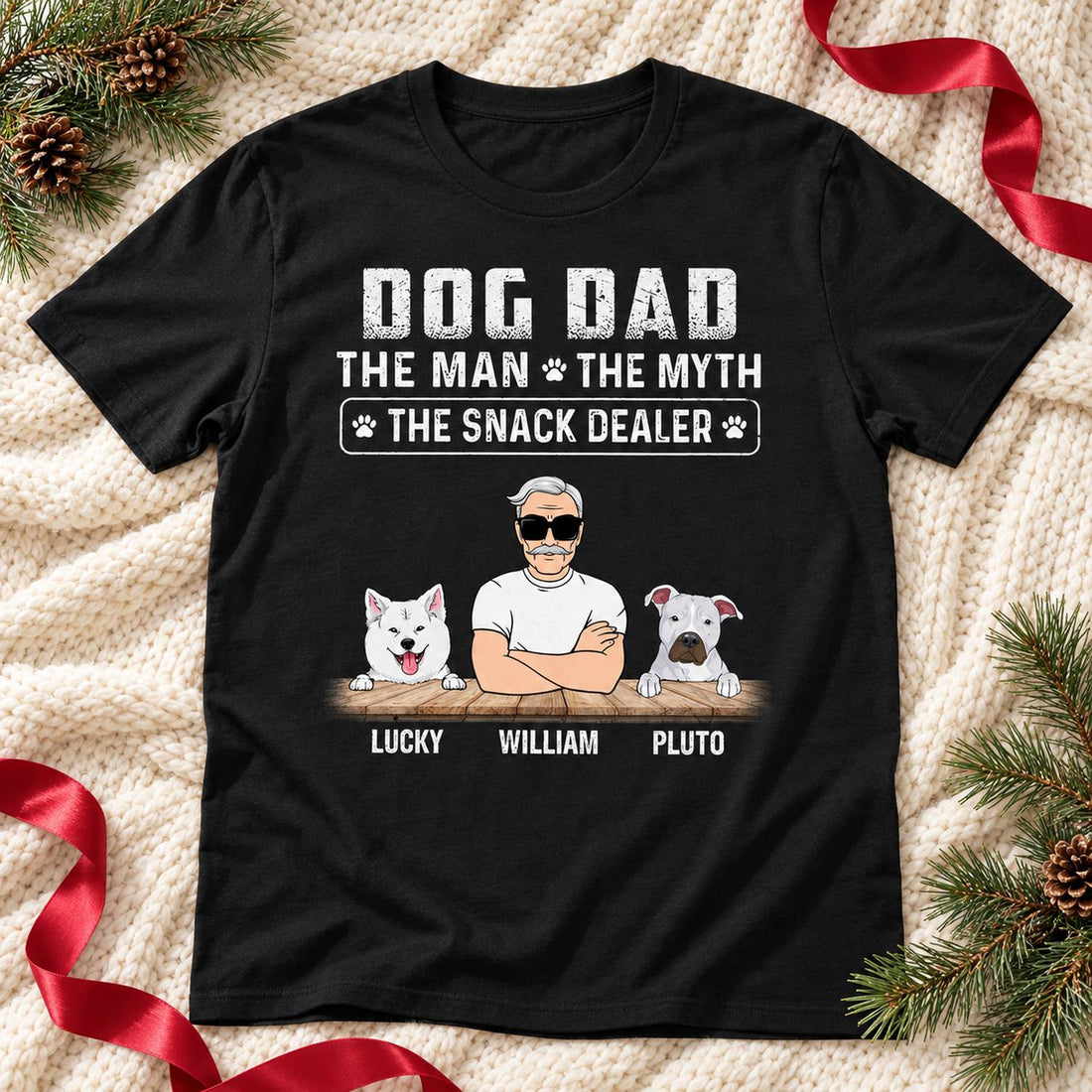 Personalized Dog Dad Snack Dealer t-shirt laid flat on a knit blanket with holiday greenery