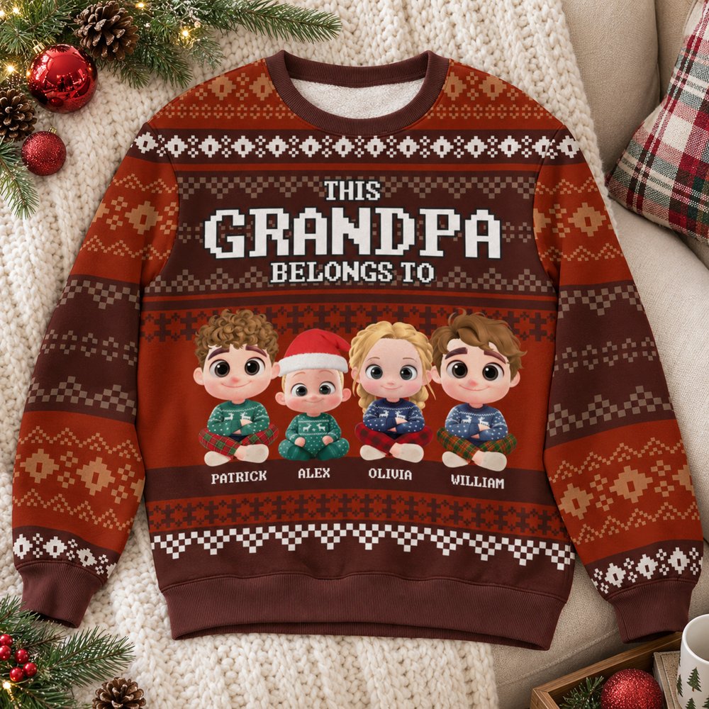 Personalized Grandpa ugly Christmas sweatshirt laid on a cozy sofa with holiday pine and red ornaments
