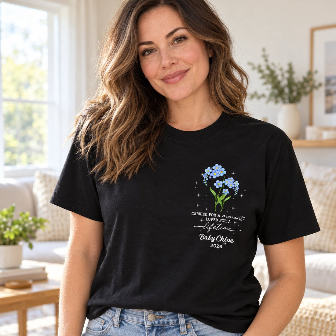 Woman wearing personalized Tiny Bloom Forever Memorial black t-shirt with blue forget-me-not chest print