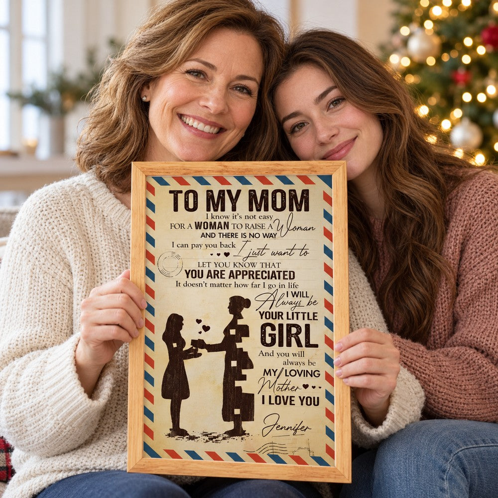Happy mom holding her personalized To My Mom framed print gift on Christmas morning