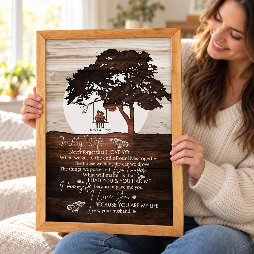 Wife happily holding her personalized To My Wife framed wall art gift in a bright room