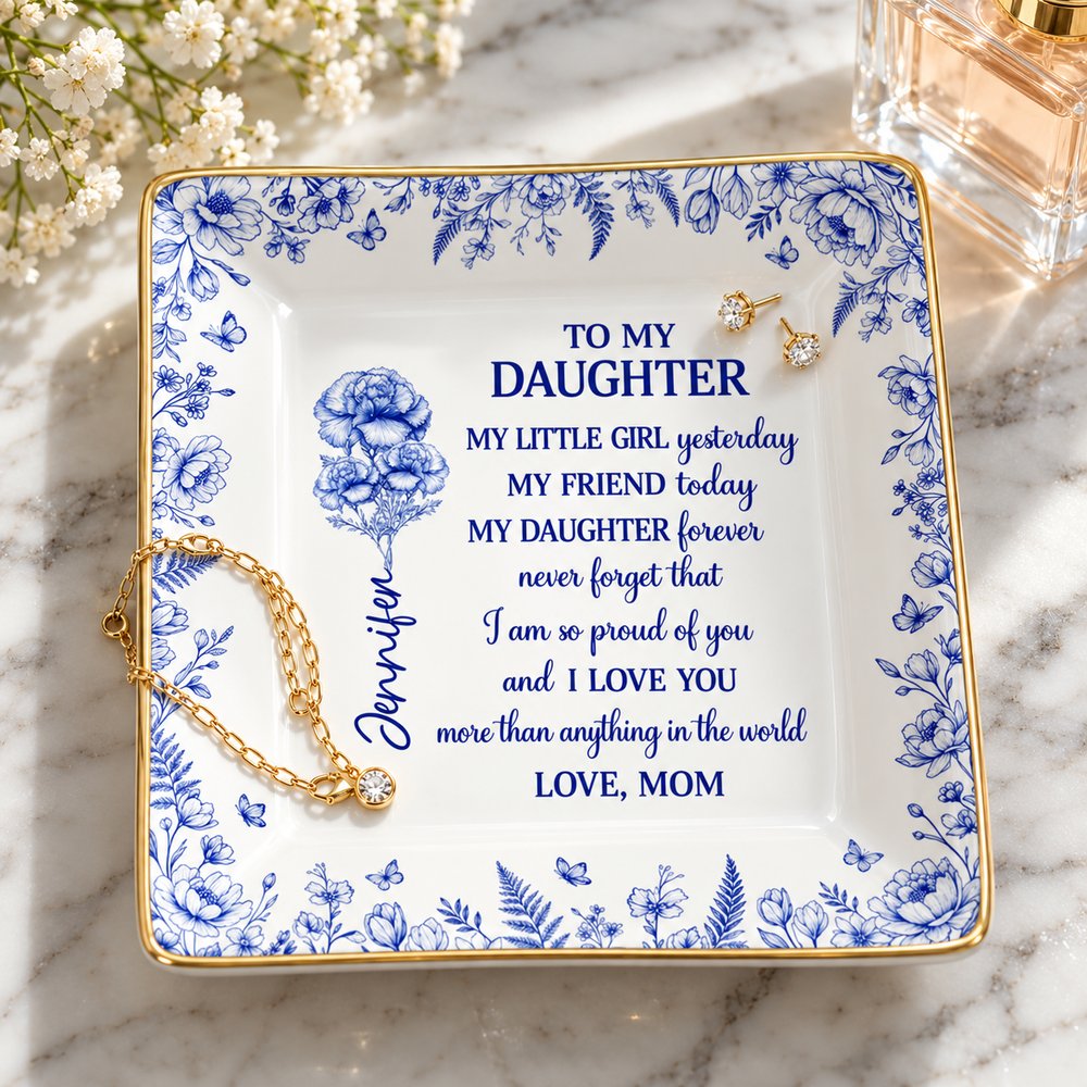 Custom birth flower ceramic ring dish holding gold jewelry on a marble dresser