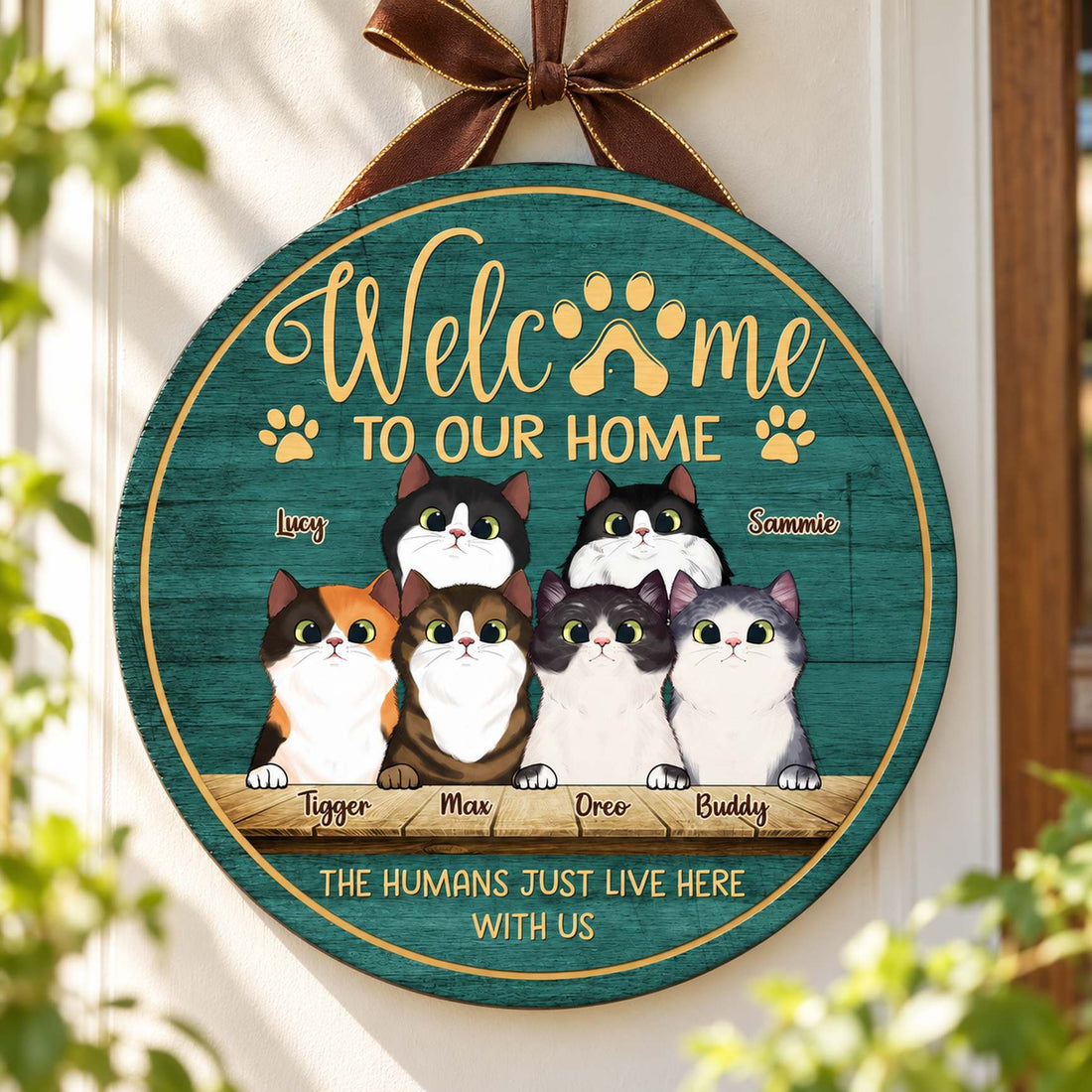 Personalized peeking cats round wood sign hanging on an entryway wall
