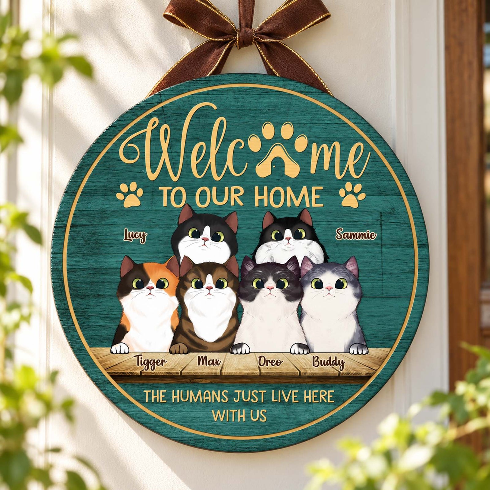 Personalized peeking cats round wood sign hanging on an entryway wall
