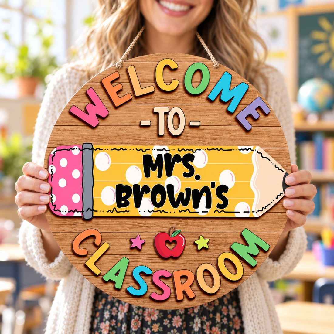 Happy female teacher holding her personalized Mrs Browns Classroom round wood sign