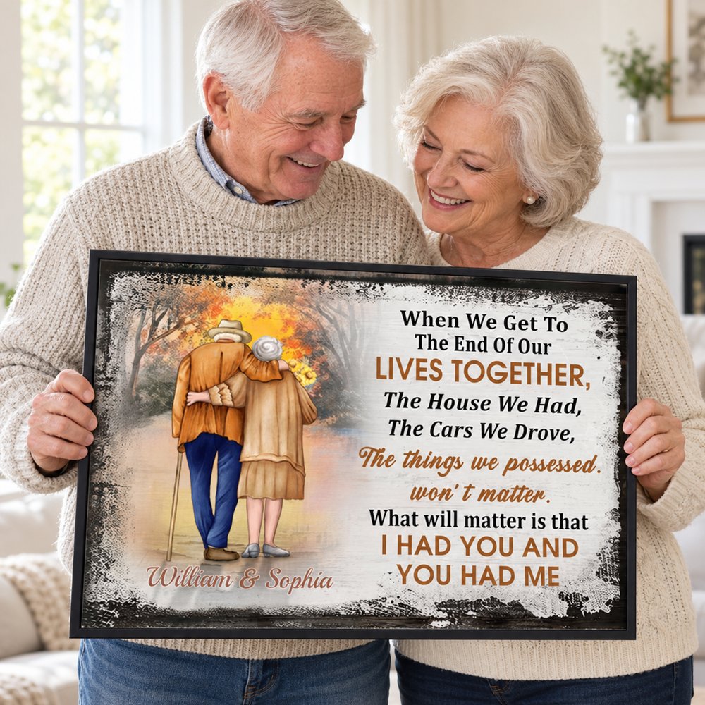 Senior couple happily holding their personalized anniversary canvas print in a bright room