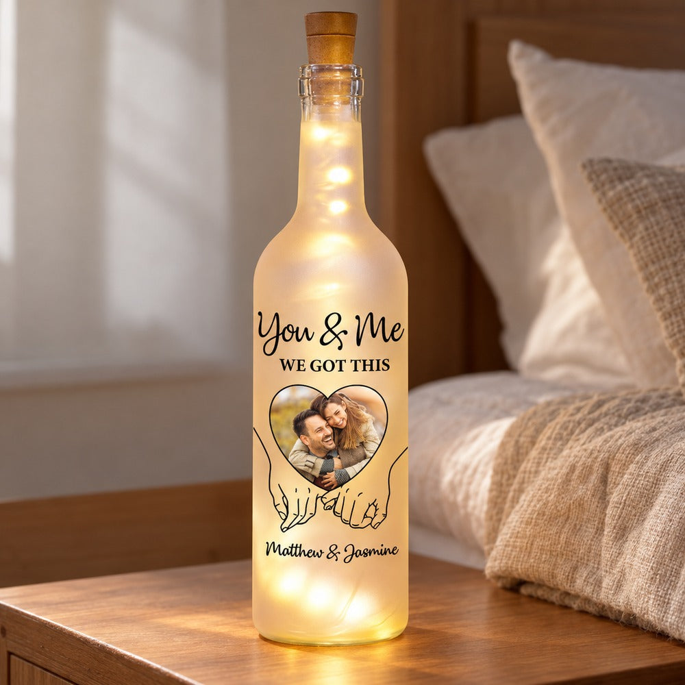 Custom You and Me couple bottle light displayed on a cozy bedroom nightstand