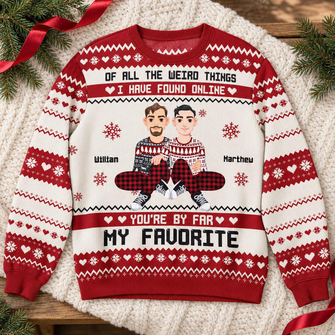 Personalized couple ugly Christmas sweater flat lay with holiday greenery