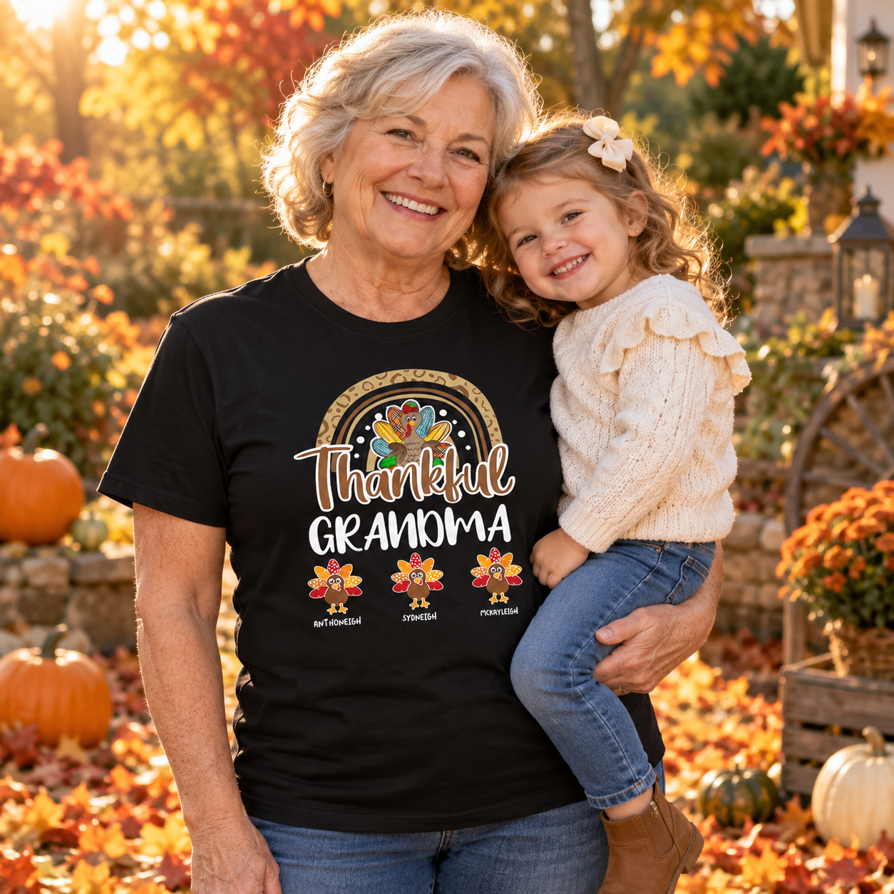 Grandma in a custom Thankful Grandma t-shirt holding a grandchild among autumn leaves and pumpkins