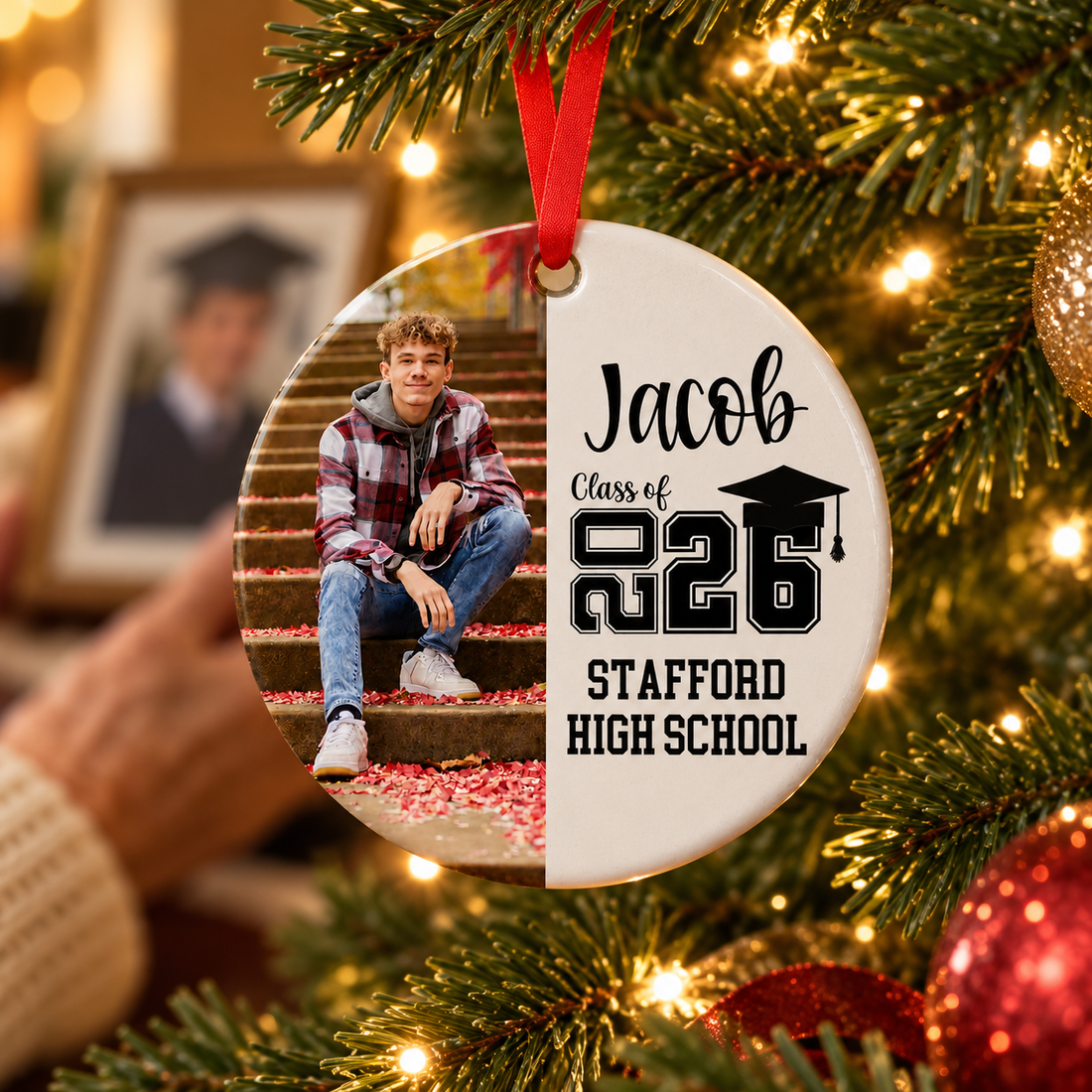 Personalized senior keepsake ceramic ornament hanging on a lit Christmas tree