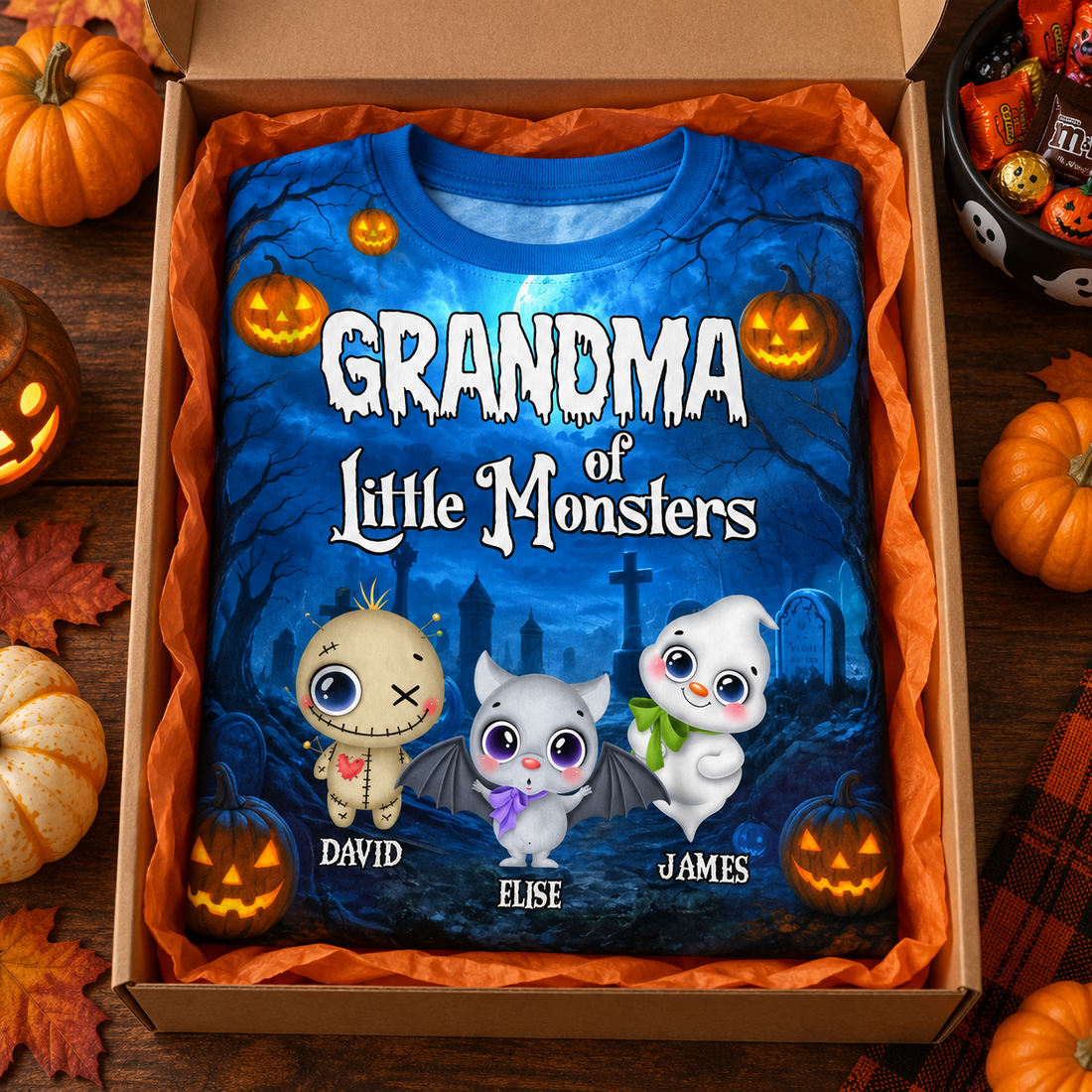 Personalized all-over-print Halloween t-shirt in an open gift box with pumpkins and candy