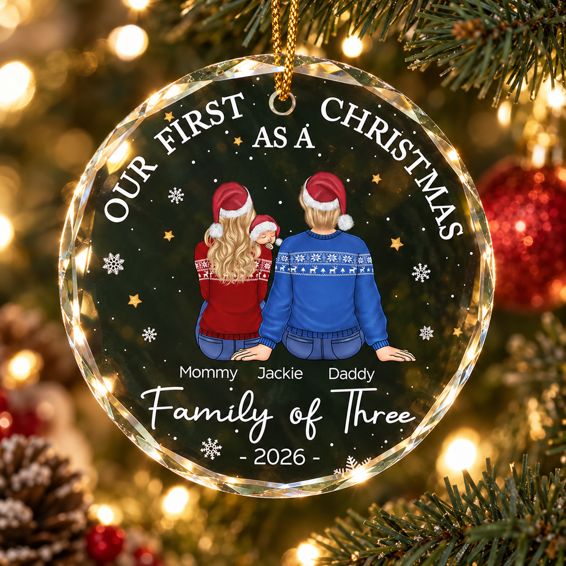 Personalized family of three glass Christmas ornament hanging on a lit tree