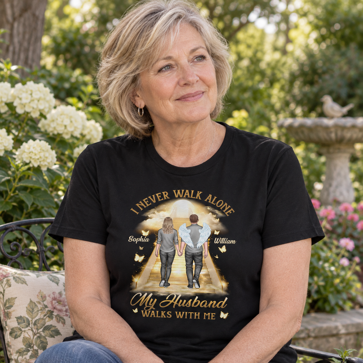 Widow wearing a personalized memorial t-shirt I Never Walk Alone in a quiet garden
