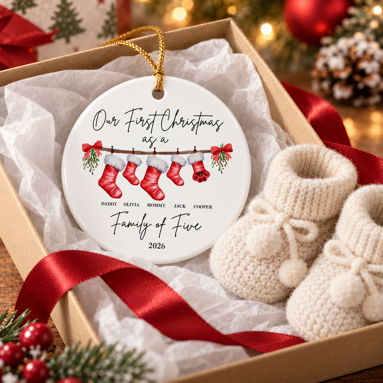 Custom first Christmas family ceramic ornament in a gift box with tissue and baby booties