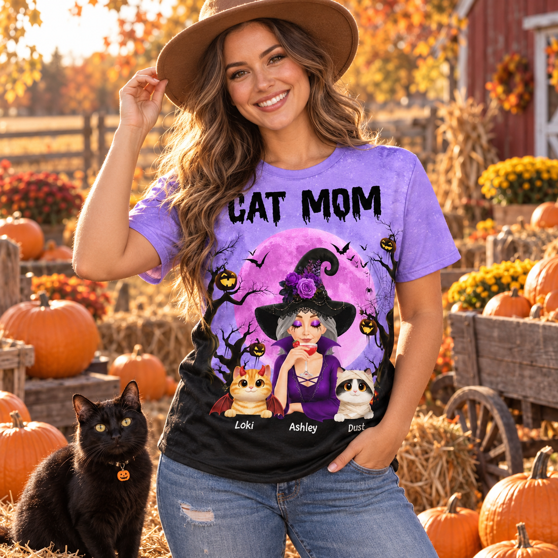 Woman in a spooky cat mom witch all-over print t-shirt at a pumpkin patch with a black cat