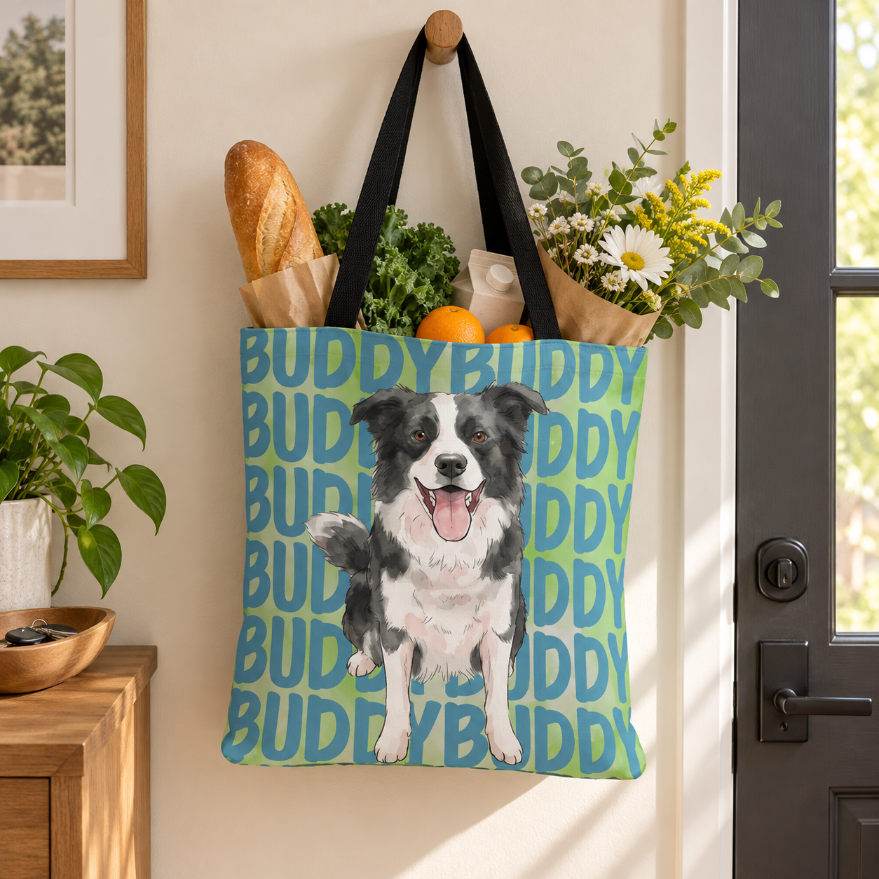 Personalized pet portrait tote bag hanging by a door with groceries and flowers