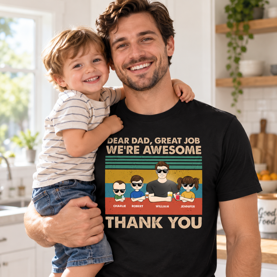 Young dad wearing a personalized Dear Dad thank you t-shirt holding his child in a sunny kitchen