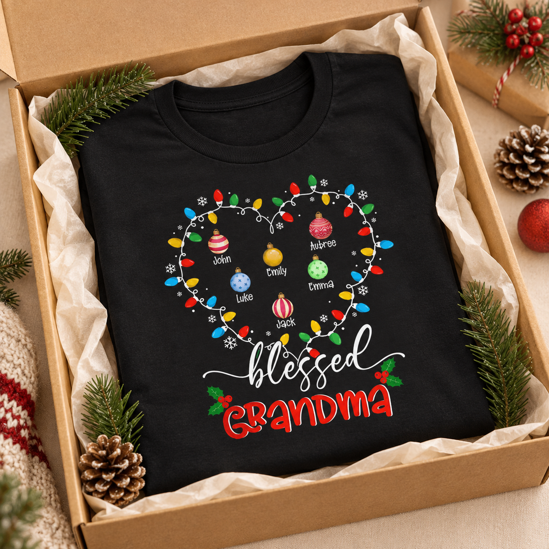 Black Blessed Grandma personalized Christmas lights t-shirt folded in a kraft gift box with pine sprigs