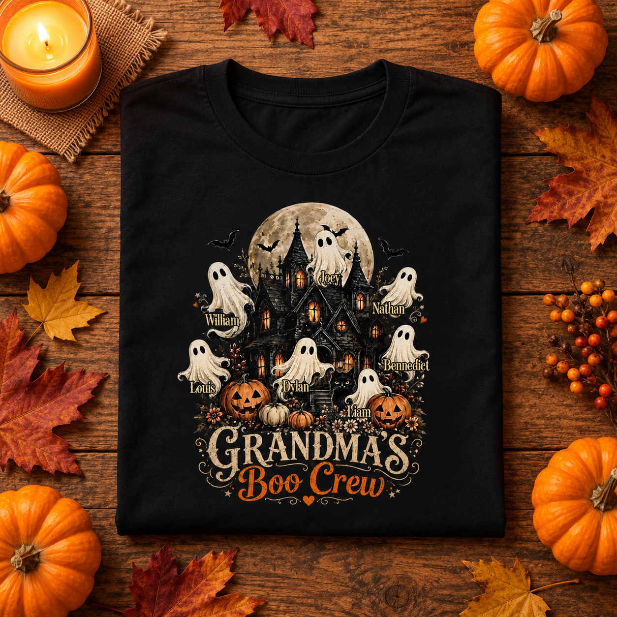 Black Grandma's Boo Crew haunted house t-shirt folded on a wooden table with pumpkins