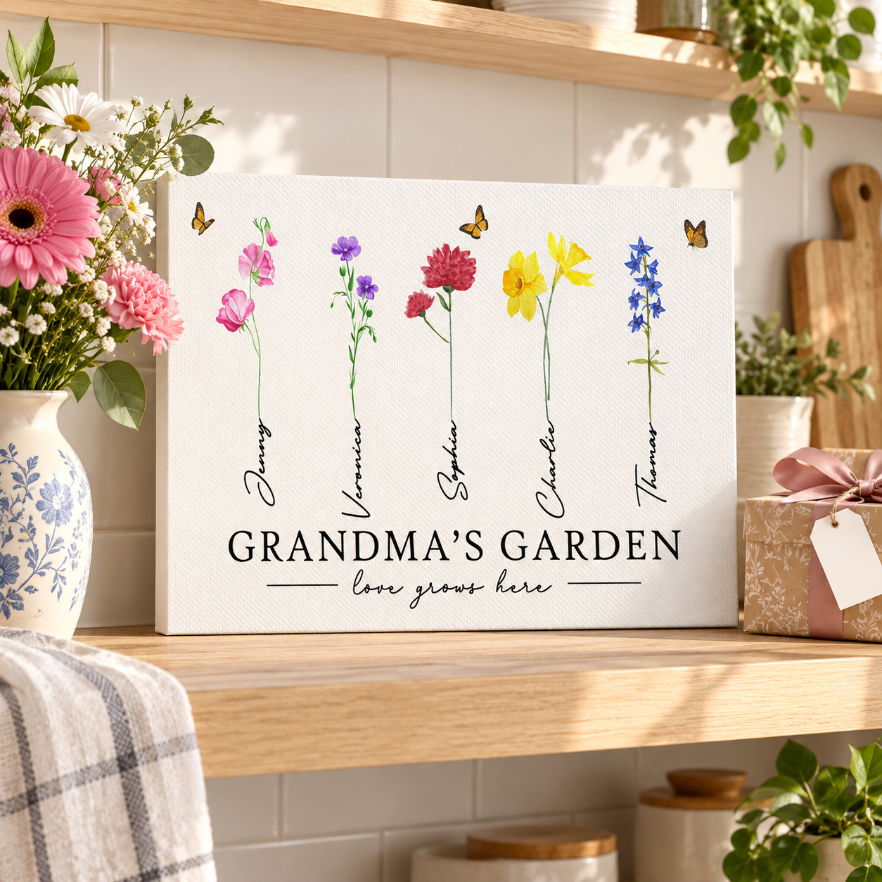 Custom Grandma's Garden birth month flowers canvas on a kitchen shelf beside flowers and a gift