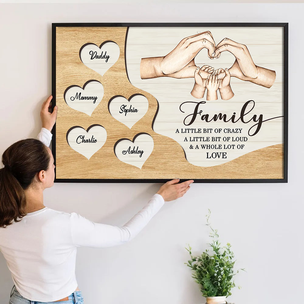 Personalized Family Hands A Whole Lot Of Love canvas print, a woman hanging the framed print on a wall